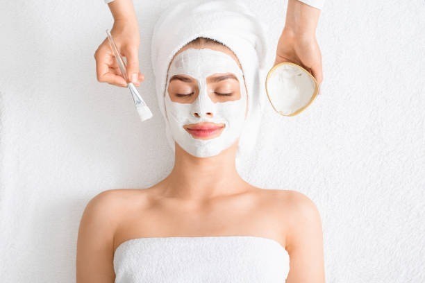 spa-therapist-putting-facial-mas